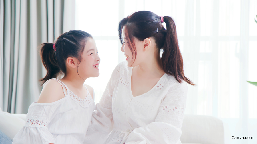 Jeune fille d'origine ethnique asiatique échangeant et souriant avec sa maman