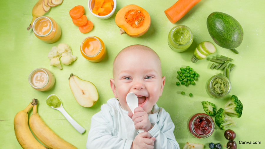 bébé souriant entouré d'aliments jaunes, oranges, verts et rouges