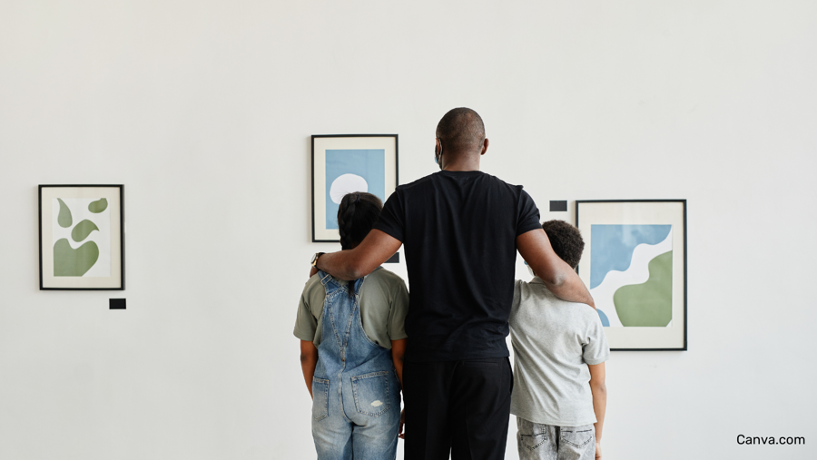 père et ses deux enfants observant des oeuvres d'art