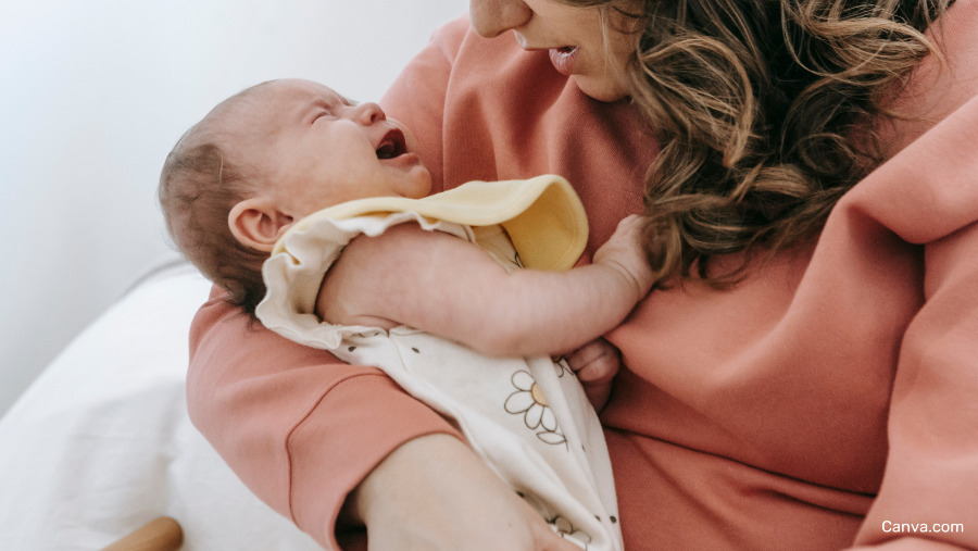 bébé pleurant dans les bras de sa maman. Maman lui parlant.