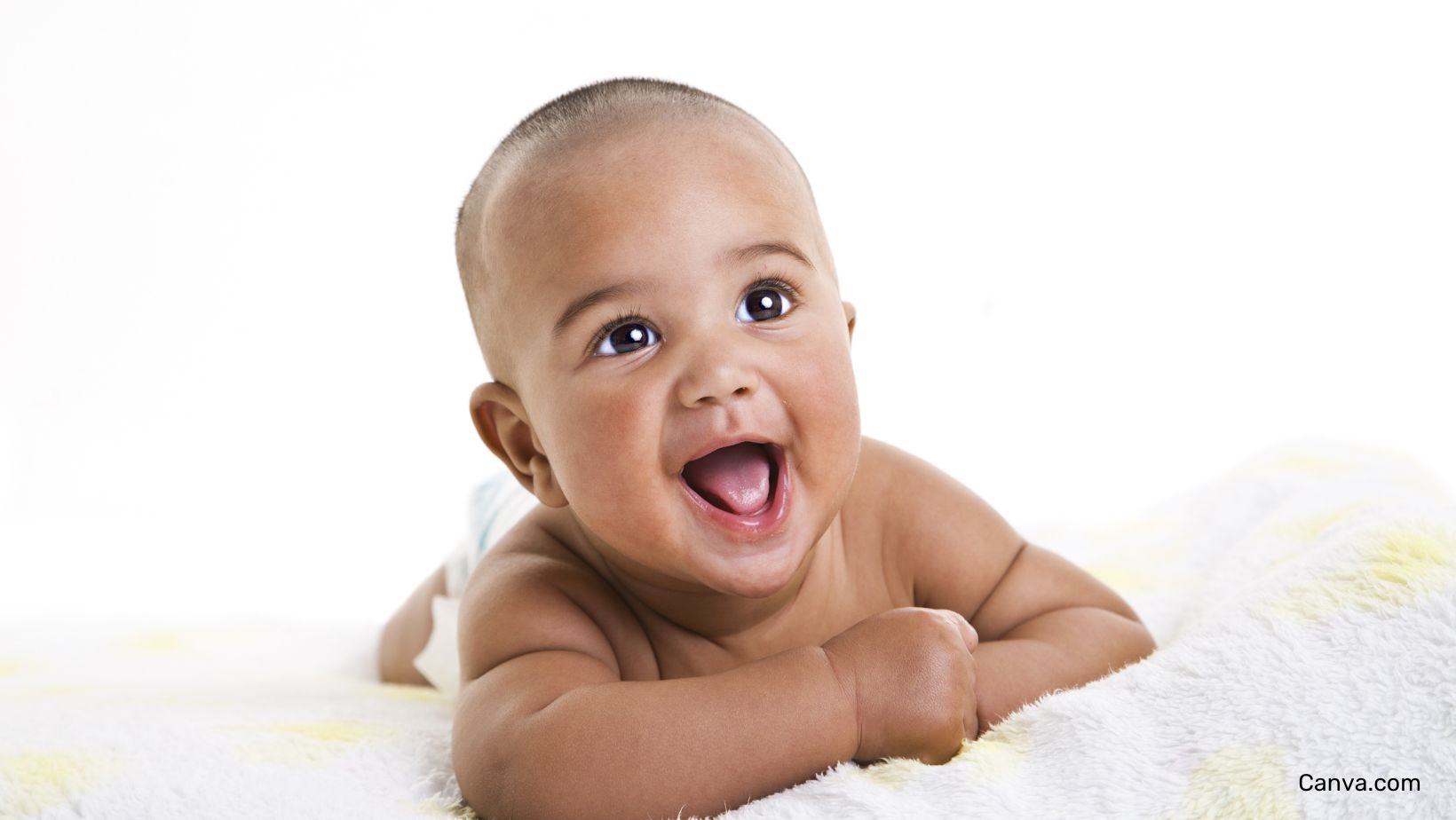 bébé souriant, allongé sur une couverture